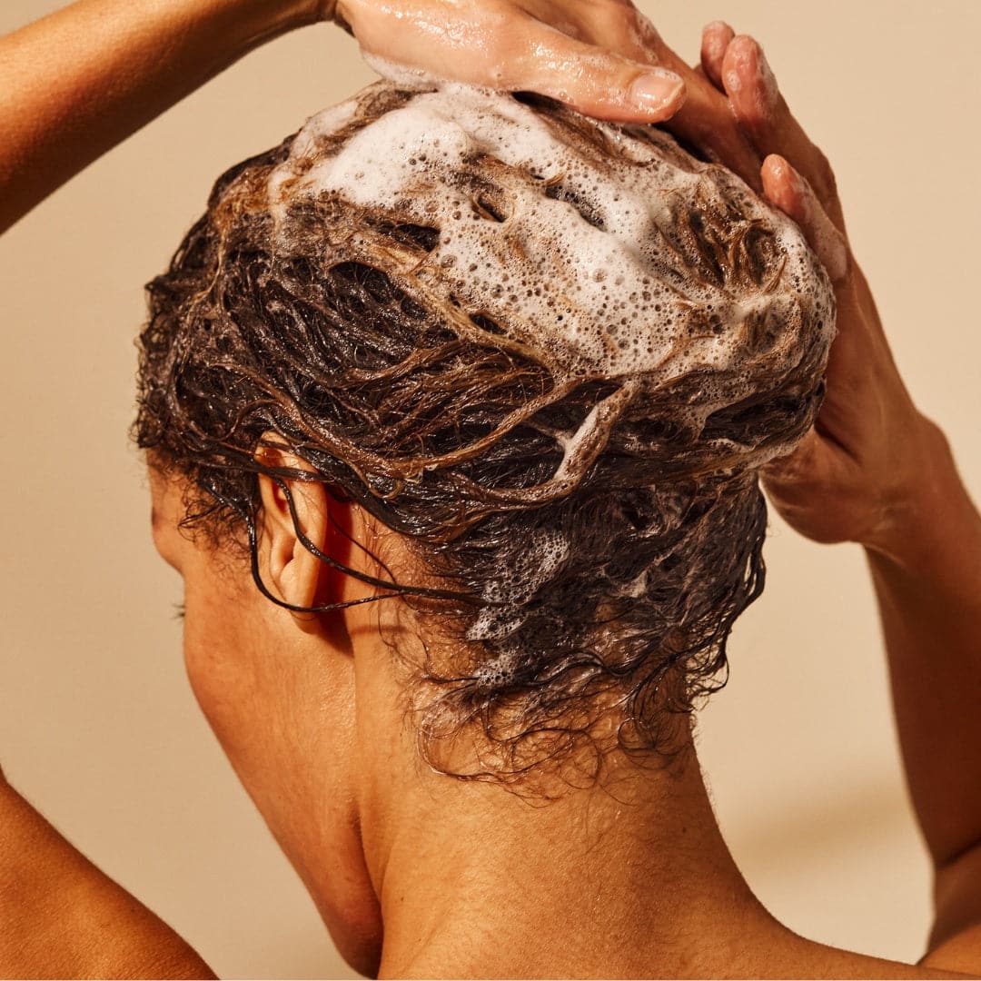 shampoo woman washes frizzy hair